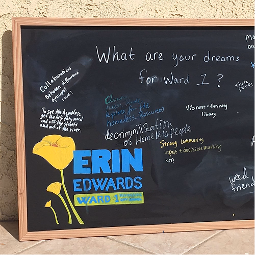 A chalkboard sign asking What are your dreams for Ward 1?, covered in handwritten answers around the Erin Edwards poppy logo